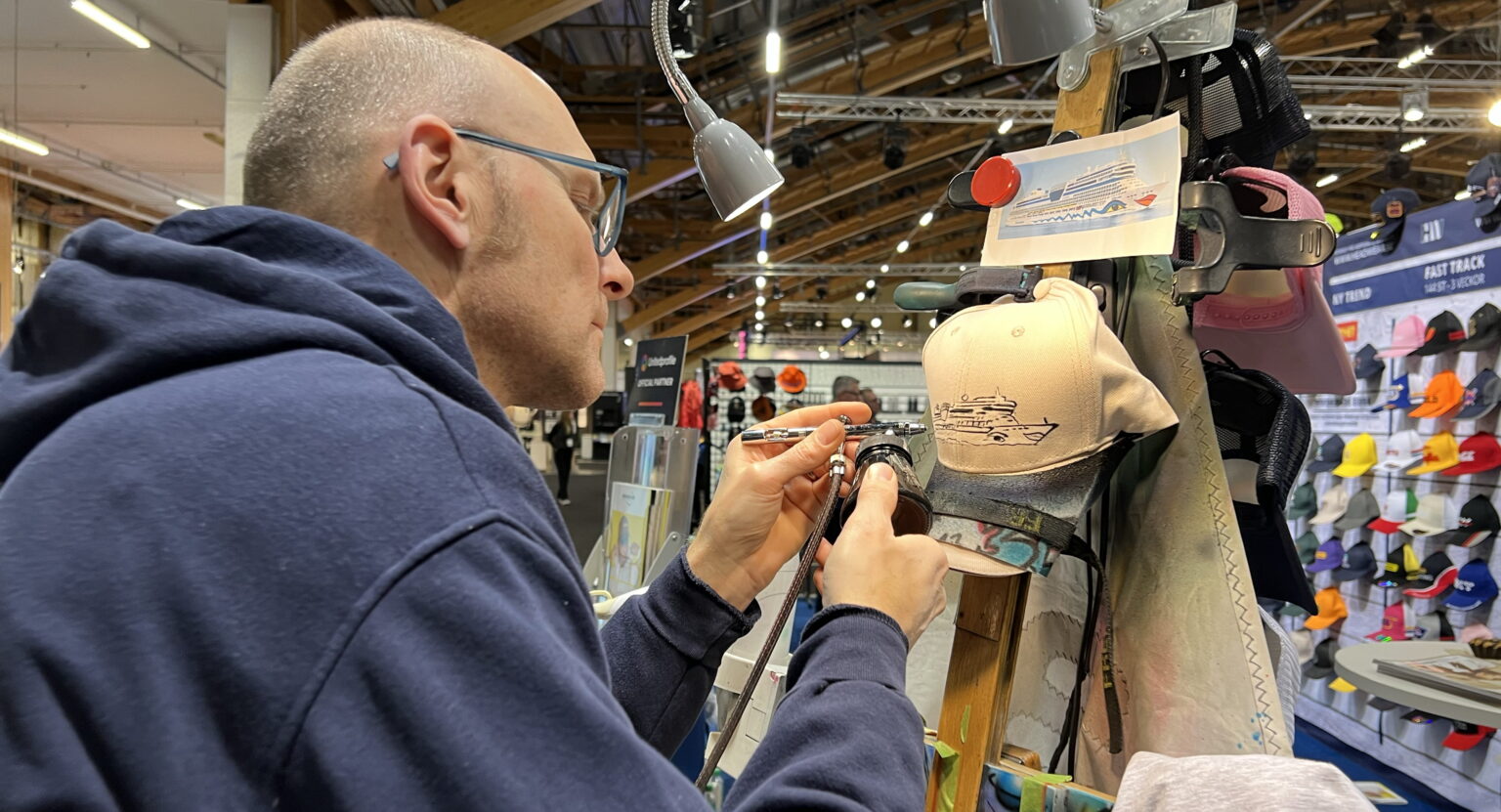 Headwear hade med sig en tysk konstnär till mässan som stod och målade kepsar på beställning av besökarna.